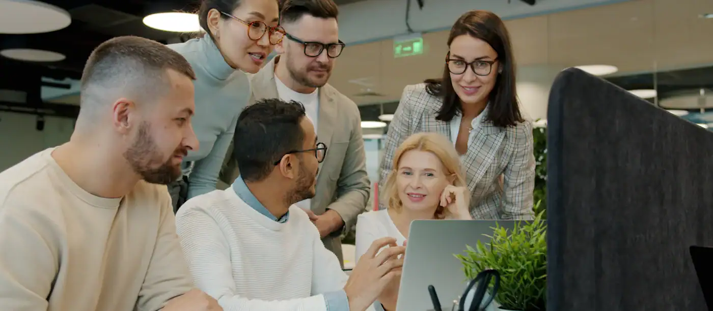 Team arbeitet gemeinsam am Laptop: Workshop zur KI-Strategie mit der KI-Agentur DATUREX